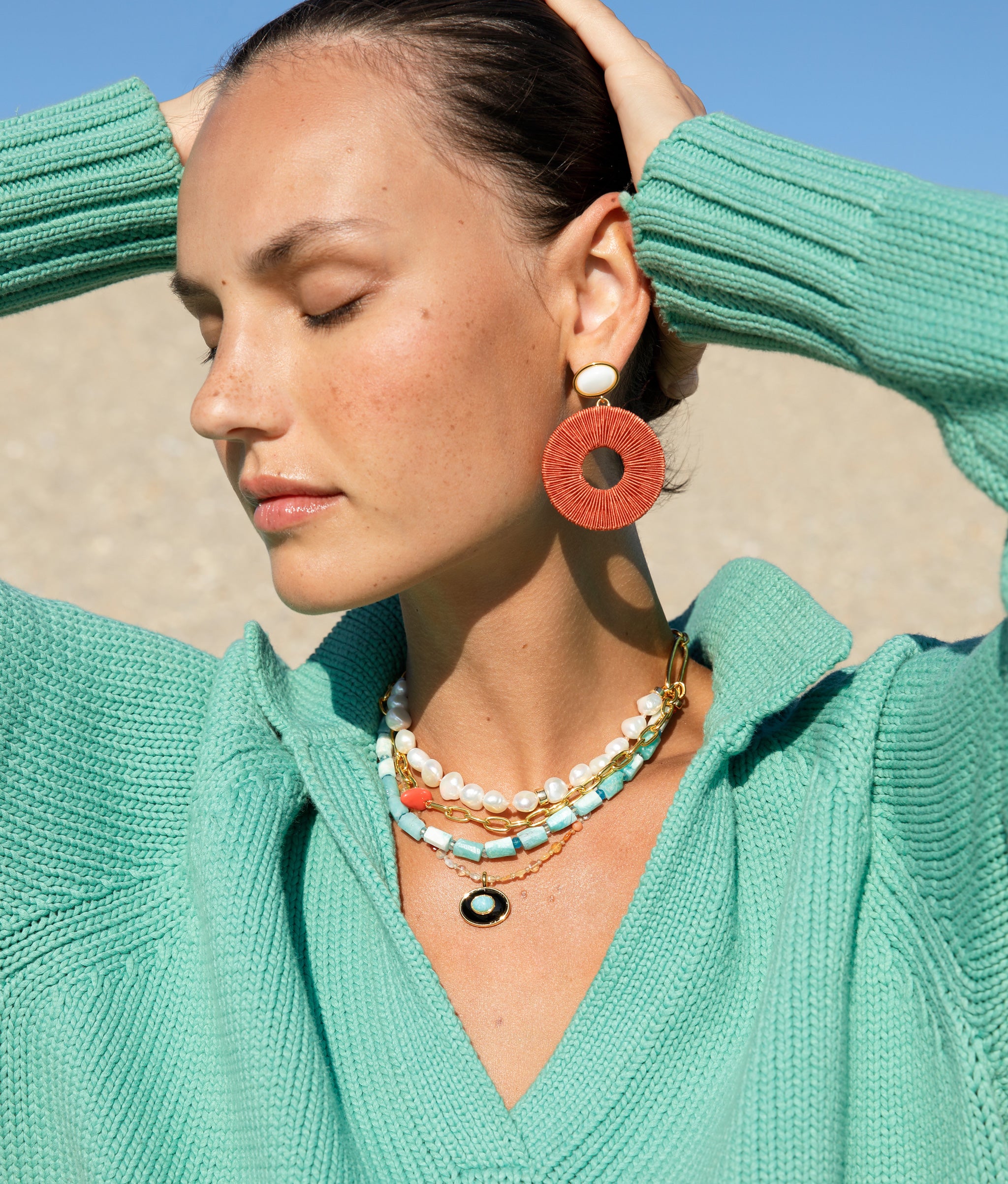 Close-up of model wearing the Vizcaya Necklace in Surf with the Granada Earrings.