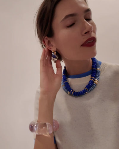 Video of model in white sweater with Laguna Necklaces in Sky Blue and Dark Electric Blue, Mini Organic Hoops in Electric anld Arc Cuff in Lilac