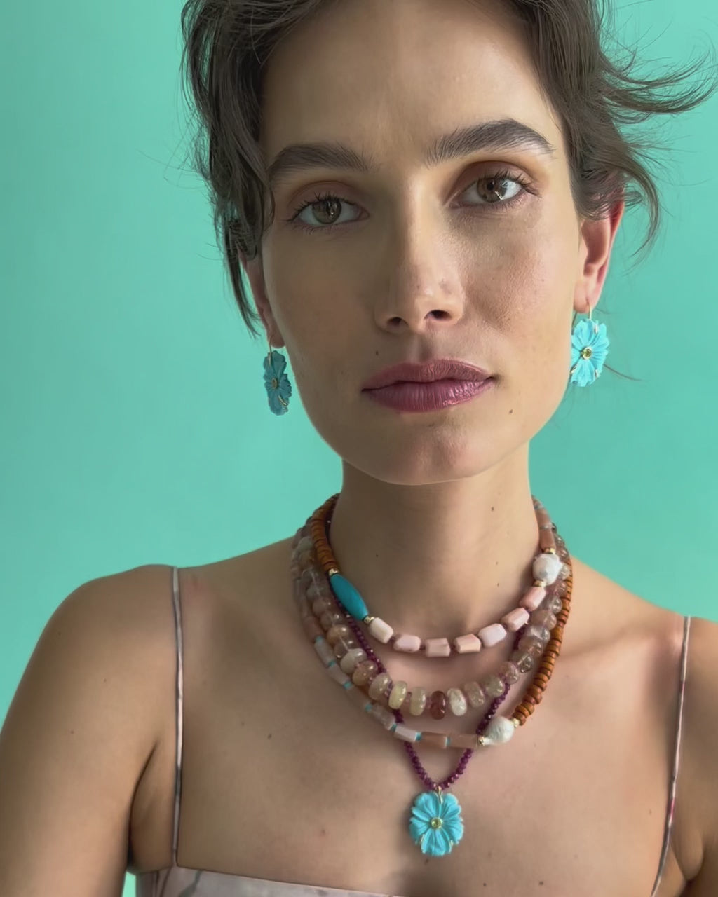 Video of model on blue backdrop in floral dress, with assorted jewelry including Cabana Necklace in Savannah.