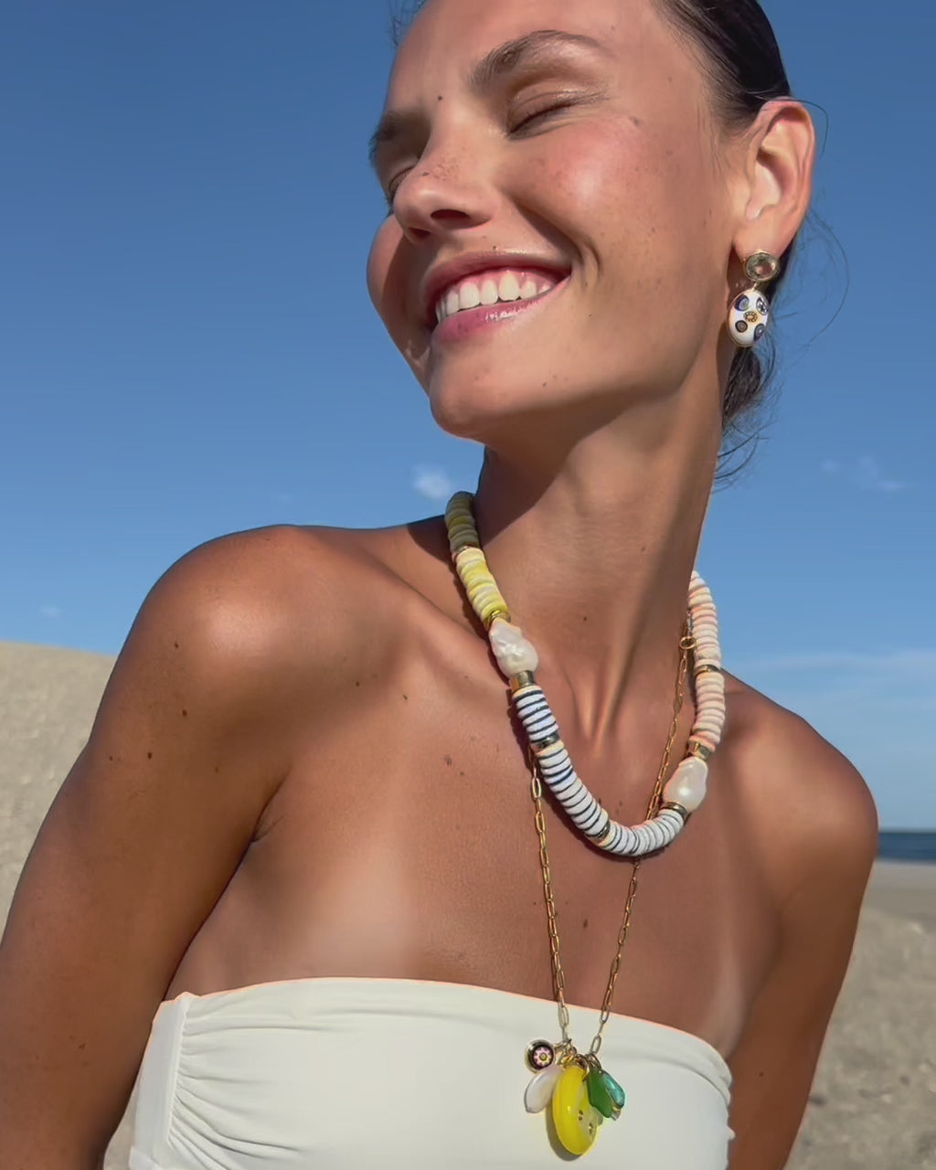 Video of model at the beach wearing Tavira Necklace in Daydream, Murano Muse Earrings in Dawn and Rivas Charm Necklace.