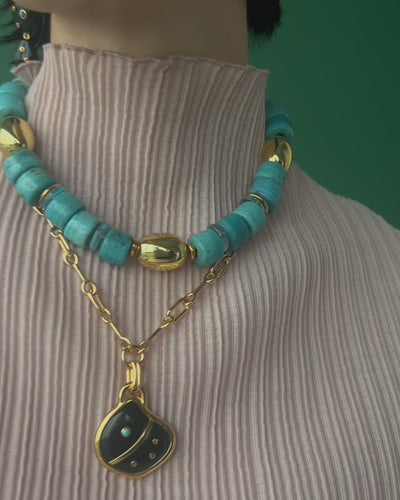 Close-up video of model wearing Varuna Collar and Agate Shell Pendant Necklace.