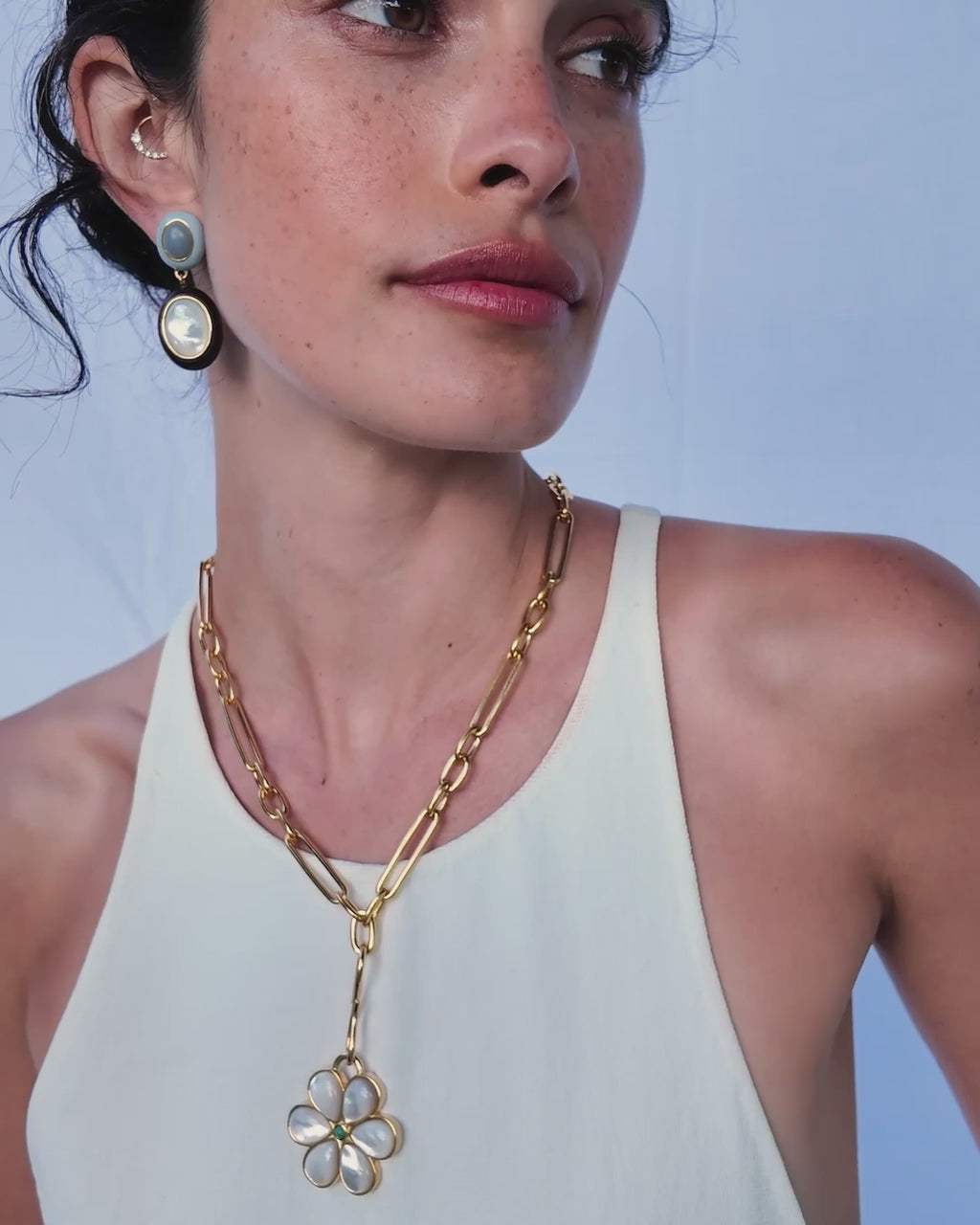 Video of model Model wearing white tank top with Venice Chain,  Daisy Pendant, and Papaya Earrings.