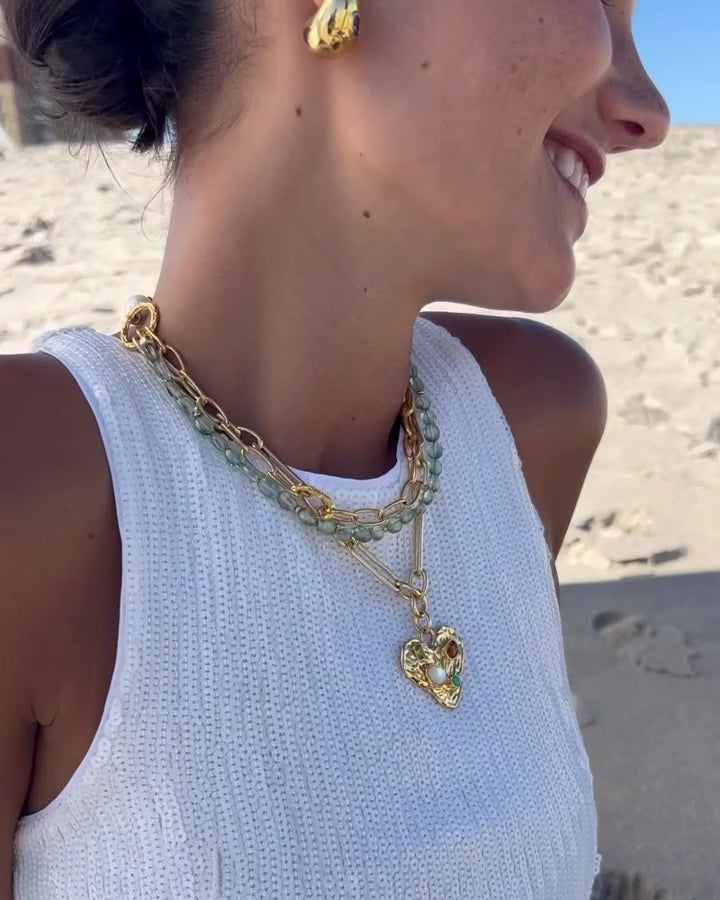 Close-up video of model at the beach wearing Treasure Trove Necklace.