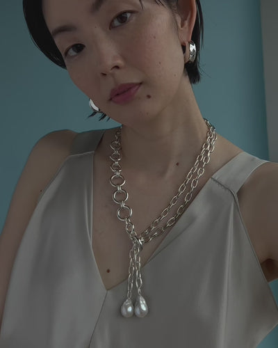 Close-up video of model wearing Edith Lariat In SIlver and Onda Hoops In Silver.