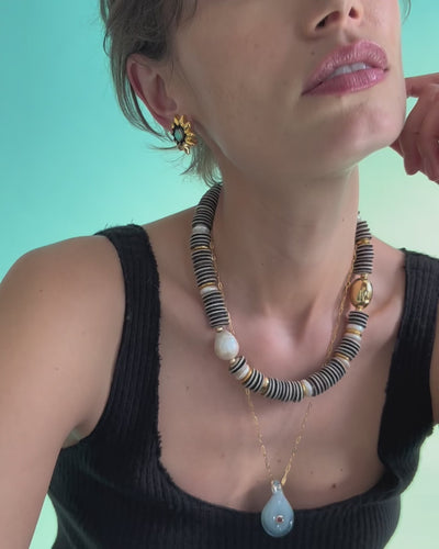 Video of model close-up in black tank with Helios Stud Earrings, Prairie Necklace in Zebra and Muse Pendant in Rain.