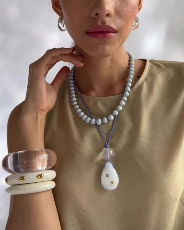 Video shows model wearing Matilde Cord Necklace styled with Seaside Cliffs Necklace and Lizzie Fortunato's cuffs.