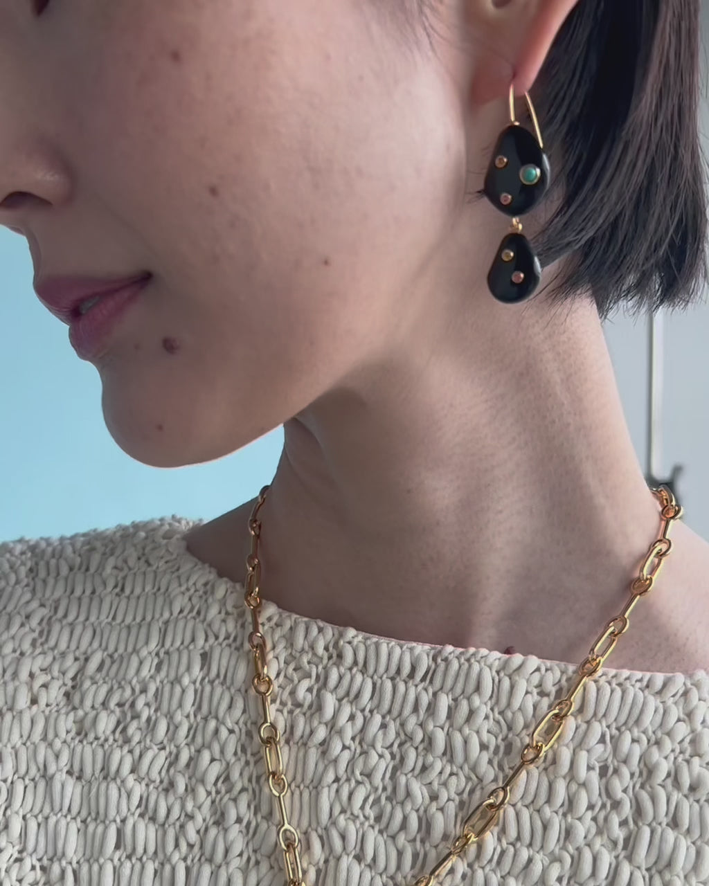 Video shows a close-up of model wearing Stacked Stone Earrings In Black Agate