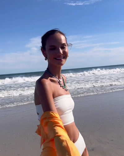 Video of model at the beach wearing Nazar Necklace paired with Blue Fields Necklace and Pearl Pablo Earrings in Citrine.