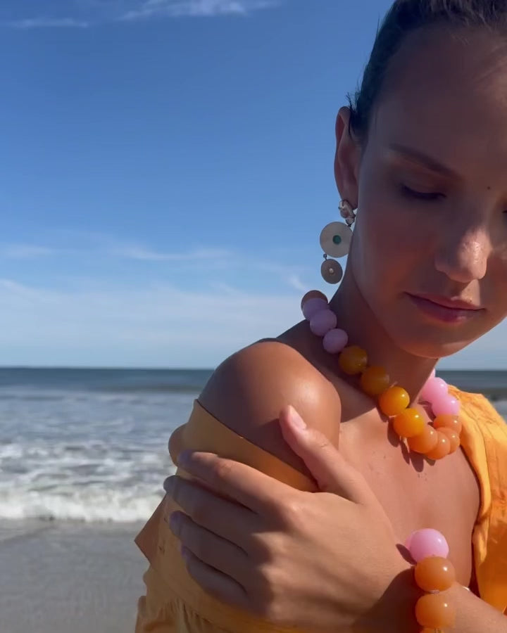 Video close up of Model at the beach wearing Olympia Bracelet and Collar set paired with Tropic Pearl Earrings.