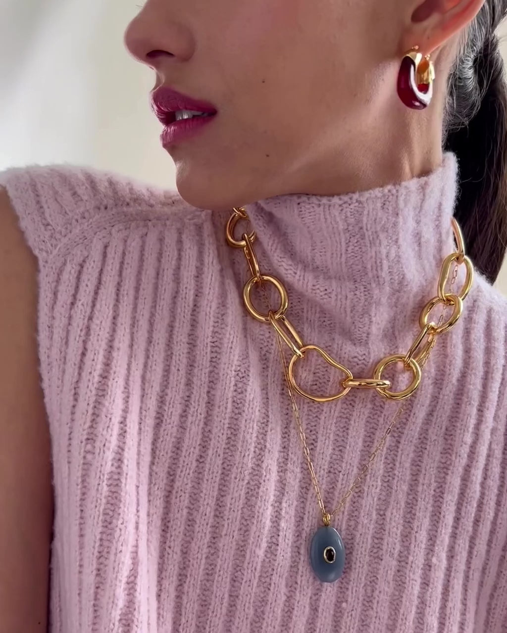 Video shows model wearing Mini Organic Hoops in Currant styled with Porto Chain and Atelier pendant Necklace.