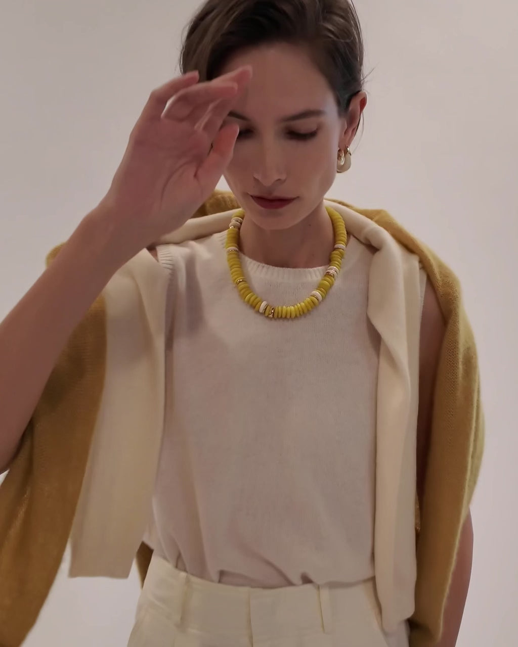 Model wears cream and yellow sweaters with Laguna Necklace in Neon Yellow and Organic Hoops in Alabaster