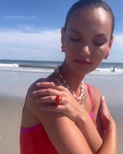Video of model wearing the Beaded Reef Necklace paired with the Rosado Necklace and red chunky star-shaped earrings.