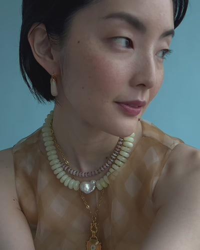 Videos has model wearing Mini Organic Hoops in Dove featuring Santo Necklace Petal and Provence Necklace In Serpentine