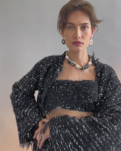 Video of model posing on grey backdrop in black textured outfit with Aquarius Collar and Taj II Earrings.