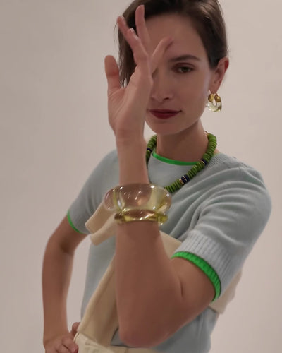 Model wears light blue sweater with Laguna Necklace in Pistachio and Organic Hoops in Lime