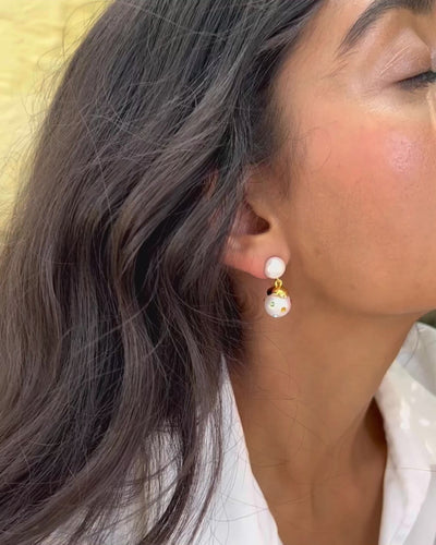 Video close up of the confetti drop earrings in white on model.